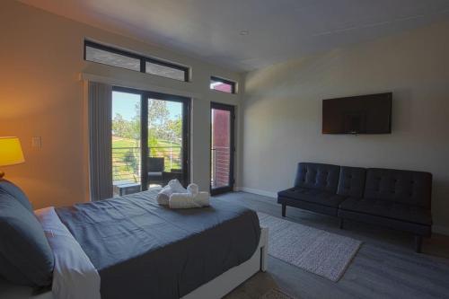 Un dormitorio con una cama, un sofá y un televisor. en Awesome Balboa and Downtown View with Cozy Patio, en San Diego