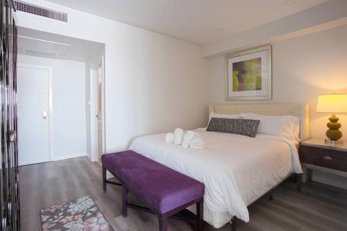 ein Schlafzimmer mit einem großen Bett und einer lila Bank in der Unterkunft Luxurious Design One Bedroom Apt near Balboa Park in San Diego