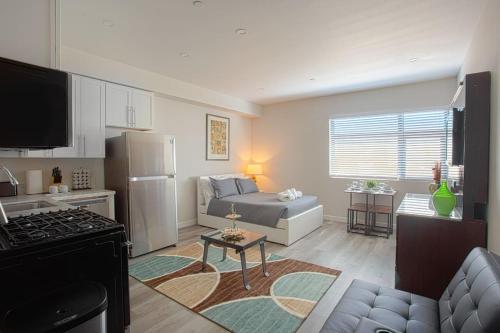 a kitchen and living room with a couch and a refrigerator at Lovely Studio w Full Kitchen in Heart of San Diego in San Diego