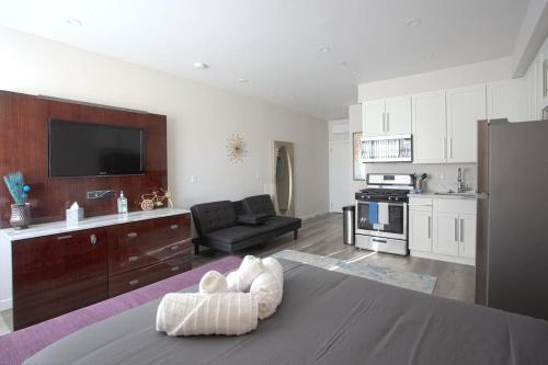 a living room with a couch and a kitchen at Luxurious Furnished Studio w Full Kitchen in SD in San Diego