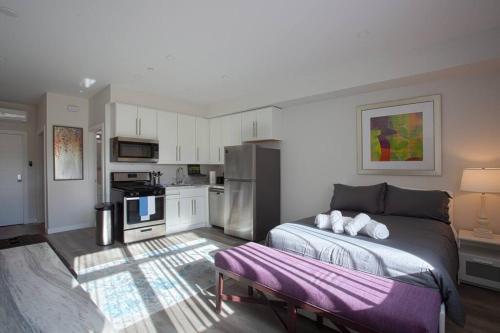 Un dormitorio con una cama grande y una cocina. en Luxurious Furnished Studio w Full Kitchen in SD, en San Diego