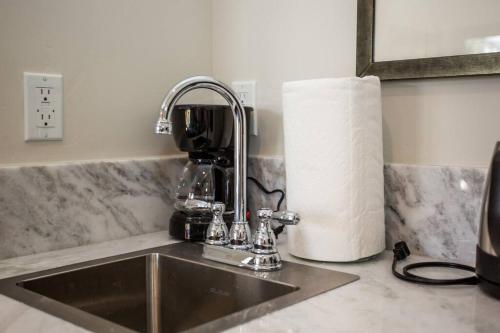 a kitchen sink with a coffee mixer and a roll of paper towels at Cute Studio With Large Balcony and Great Park View in San Diego