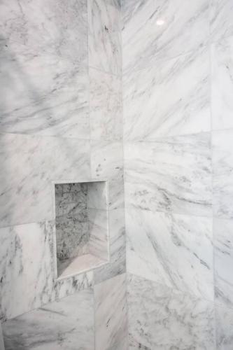 a white marble bathroom with a niche in the wall at Luxurious Furnished Studio w Full Kitchen in SD in San Diego