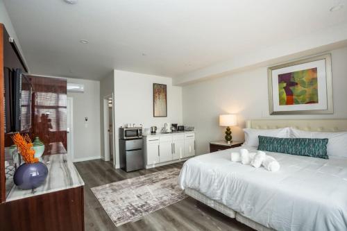 a bedroom with a large white bed and a kitchen at Luxurious Studio in Heart of San Diego w Cali King in San Diego