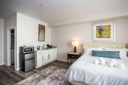 a bedroom with a white bed and a kitchen at Luxurious Studio in Heart of San Diego w Cali King in San Diego