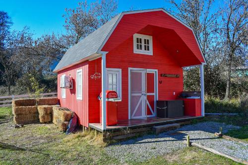a red house with hay bales around it at Cabañas El Desván in Puente Negro