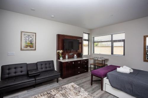 a bedroom with a bed and a couch and a tv at 2 Bedroom, 2 Bathroom Detached Apt Max 7 Sleepers in San Diego