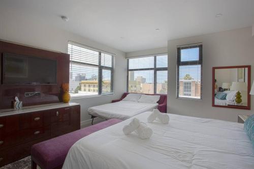 a bedroom with two beds and a flat screen tv at Downtown View 4 Sleepers Studio- Great for Getaway in San Diego