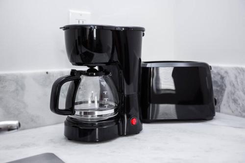 a black coffee maker on a counter next to a microwave at One Bedroom Apartment with SD Downtown View in San Diego