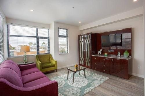 a living room with a purple couch and a tv at One Bedroom Apartment with San Diego Downtown View in San Diego