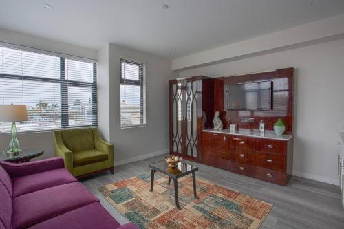 a living room with a purple couch and a mirror at Cali King Size One Bedroom Luxurious Suite in DTSD in San Diego