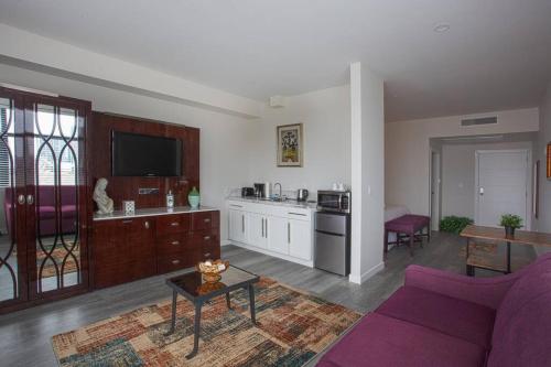 a living room with a purple couch and a kitchen at Cali King Size One Bedroom Luxurious Suite in DTSD in San Diego