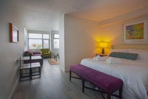 サンディエゴにあるCali King Size One Bedroom Luxurious Suite in DTSDのベッドルーム(大型ベッド1台、紫色のベンチ付)