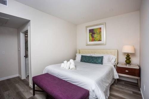 a bedroom with a large white bed with a purple bench at Prime Location - Awesome View -1 bedroom Apartment in San Diego