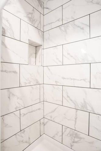 a bathroom with white marble walls and a shower at Spacious 1 Bedroom Apartment in Balboa Park in San Diego