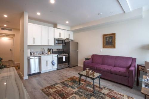 a living room with a purple couch and a kitchen at Spacious 1 Bedroom Apartment in Heart of San Diego in San Diego