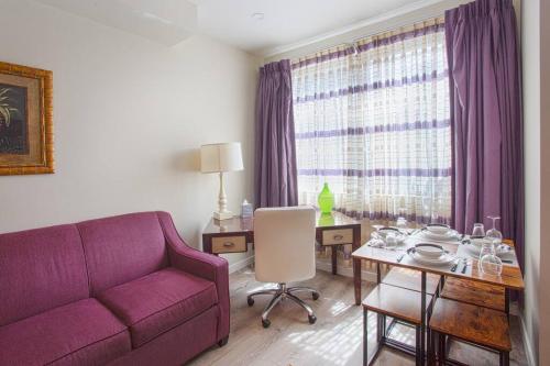 a living room with a purple couch and a table at Spacious 1 Bedroom Apartment in Heart of San Diego in San Diego