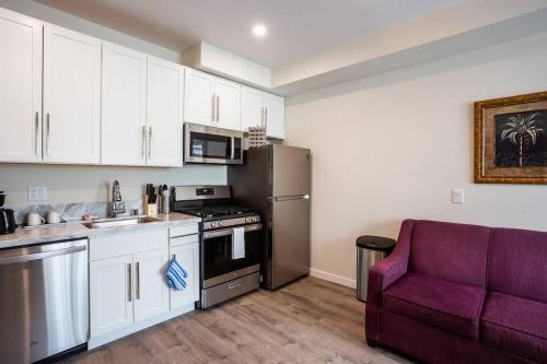 a kitchen with white cabinets and a purple couch at Spacious 1 Bedroom Apartment in Heart of San Diego in San Diego