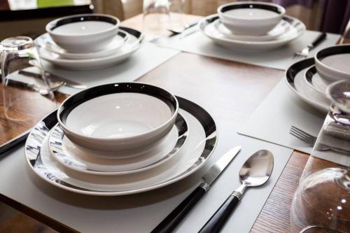 a table with white plates and bowls and spoons at Spacious 1 Bedroom Apartment in Heart of San Diego in San Diego
