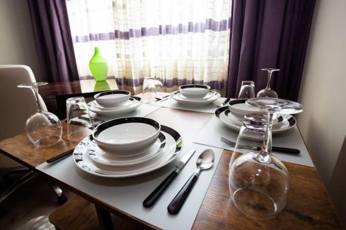 a wooden table with plates and dishes on it at Spacious 1 Bedroom Apartment in Heart of San Diego in San Diego