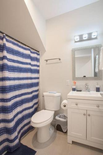 a bathroom with a toilet and a sink and a shower curtain at Spacious 1 Bedroom Apartment in Heart of San Diego in San Diego