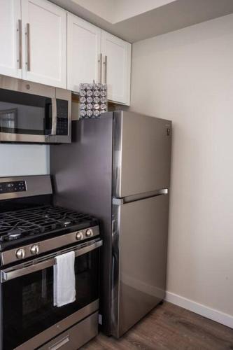 a kitchen with a stainless steel refrigerator and a stove at Spacious 1 Bedroom Apartment in Heart of San Diego in San Diego