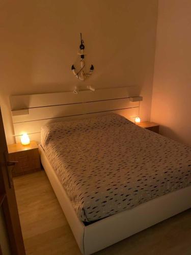 a bedroom with a bed with two lights on it at Casa Anemos in Grado