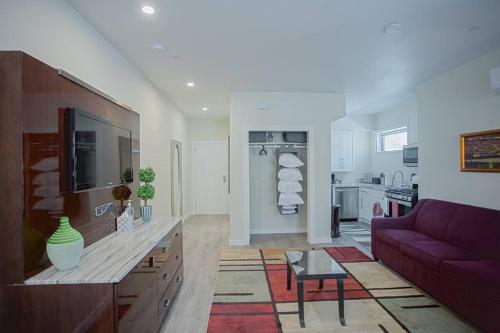 a living room with a purple couch and a kitchen at Spacious 500 sqft Studio with Balboa Park View in San Diego