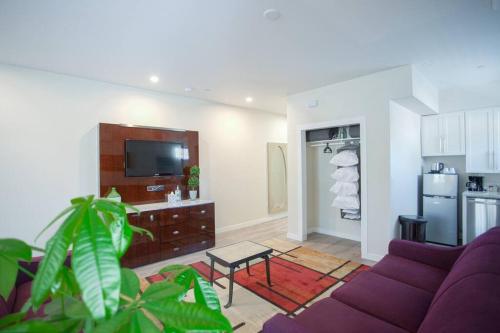 a living room with a purple couch and a kitchen at Spacious 500 sqft Studio with Balboa Park View in San Diego