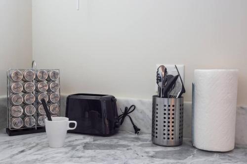 a counter with a cup and a toaster and a mug at Spacious 500 sqft Studio with Balboa Park View in San Diego