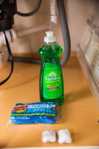 a green bottle of cleaning detergent sitting next to a toothpaste at Spacious 500 sqft Studio with Balboa Park View in San Diego