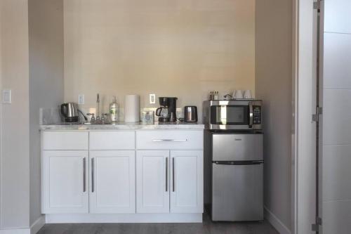 a kitchen with white cabinets and a microwave oven at Spacious Studio with Incredible Balboa Park View in San Diego