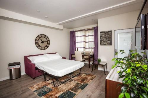 - une chambre avec un lit, une table et une horloge dans l'établissement 1 Bedroom Apartment with Luxurious Design in SD, à San Diego