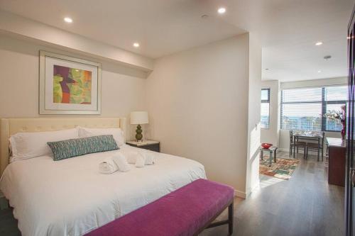 1 dormitorio con 1 cama blanca grande y banco púrpura en The Most Beautiful Bay View from 1 Bedroom Apt, en San Diego