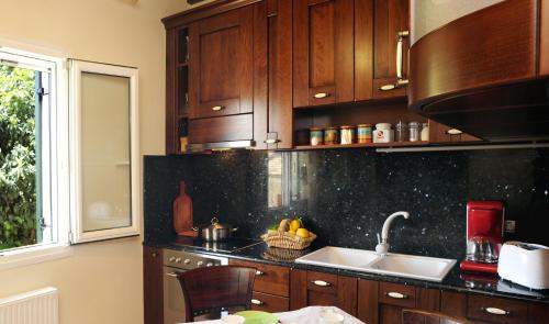 a kitchen with wooden cabinets and a sink at Villa Edem in Kassiopi