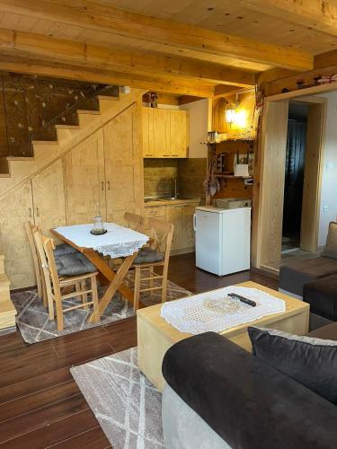 a living room with a table and a kitchen at Brvnare Dunja 1 i Dunja 2 in Kraljevo