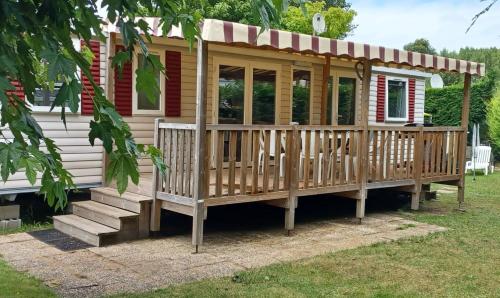 een houten hut met een veranda en een tuinhuisje bij Les Charmettes - SIBLU in Les Mathes