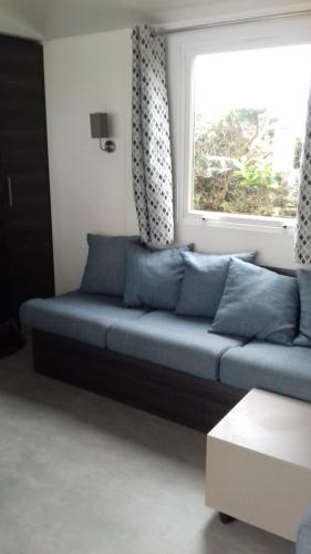 a blue couch in a living room with a window at Les Charmettes - SIBLU in Les Mathes