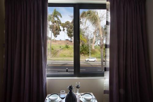 a window with a view of a white car on a street at Luxurious One Bedroom Suite with Balboa Park View in San Diego