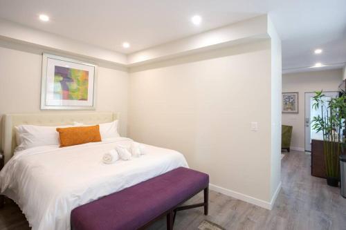 a bedroom with a large white bed with a purple bench at Luxurious One Bedroom Suite with Balboa Park View in San Diego