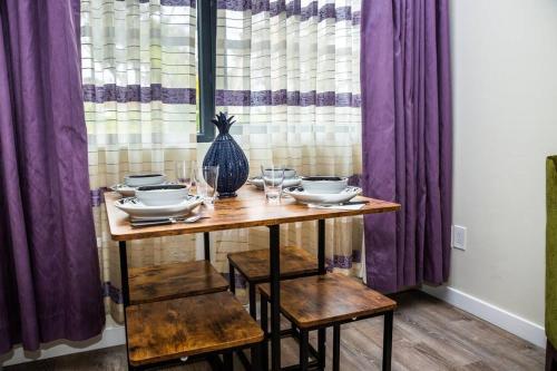a table with plates and glasses and a vase at Luxurious One Bedroom Suite with Balboa Park View in San Diego