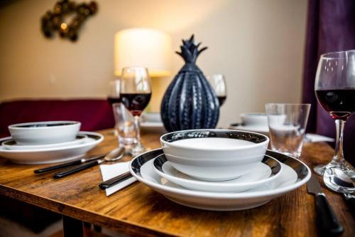 a wooden table topped with plates and glasses of wine at Luxurious One Bedroom Suite with Balboa Park View in San Diego