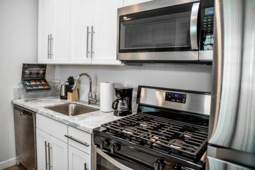 a kitchen with a stove and a microwave at Luxurious One Bedroom Suite with Balboa Park View in San Diego
