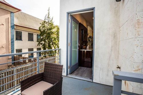 a balcony with a chair and an open door at Luxurious One Bedroom Suite with Balboa Park View in San Diego