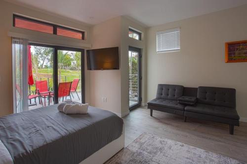聖地牙哥的住宿－Explore Balboa Park From Your Cozy Studio w Patio，一间卧室配有一张床和一张沙发,还设有一个庭院。