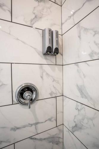 a white tiled wall with a shower in a bathroom at Modern, Luxurious and Prime location All in One in San Diego