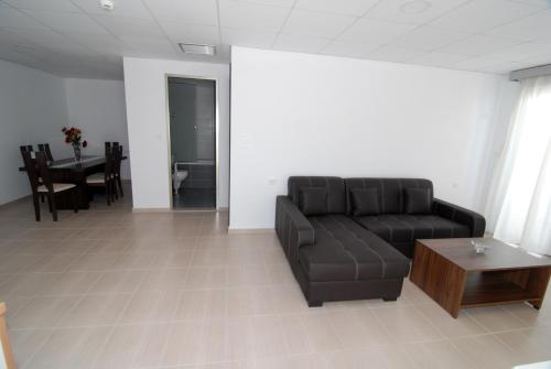 a living room with a black couch and a table at Royal Bay Suites in Kefalos