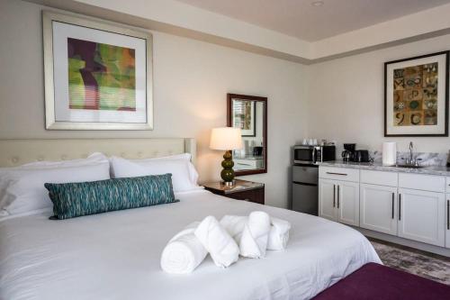 a bedroom with a white bed and a kitchen at Next to San Diego Downtown - Cali King Size Studio in San Diego