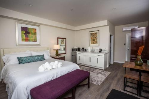 a bedroom with a large white bed and a kitchen at Next to San Diego Downtown - Cali King Size Studio in San Diego