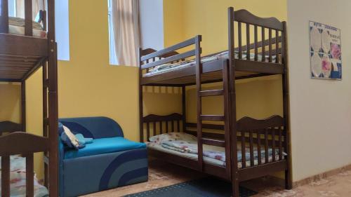 リヴィウにあるPANORAMI Apart Hostel in Lvivの二段ベッド2台と椅子が備わる二段ベッドルーム1室です。